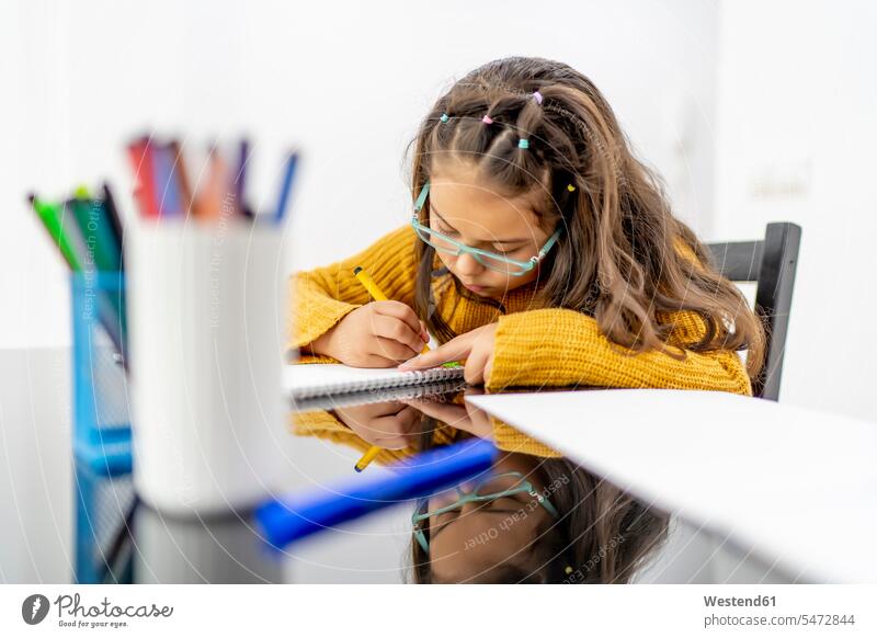 Mädchen zeichnet in Buch auf Tisch zu Hause Farbaufnahme Farbe Farbfoto Farbphoto Innenaufnahme Innenaufnahmen innen drinnen 8-9 Jahre 8 bis 9 Jahre Kinder Kid