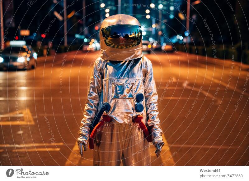 Spaceman stehend auf einer Straße in der Stadt bei Nacht Raumfahrer Weltraumfahrer Astronaut Astronauten Strassen Straßen staedtisch städtisch nachts steht