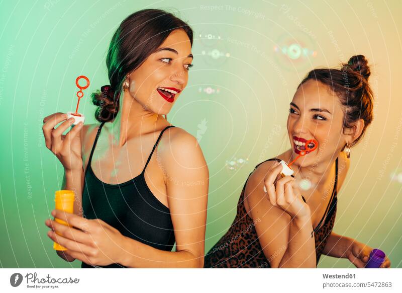 Porträt von zwei Freunden, die sich mit Seifenblasen vergnügen Kameradschaft Freundin fliegend Jahreszeiten sommerlich Sommerzeit begeistert Enthusiasmus