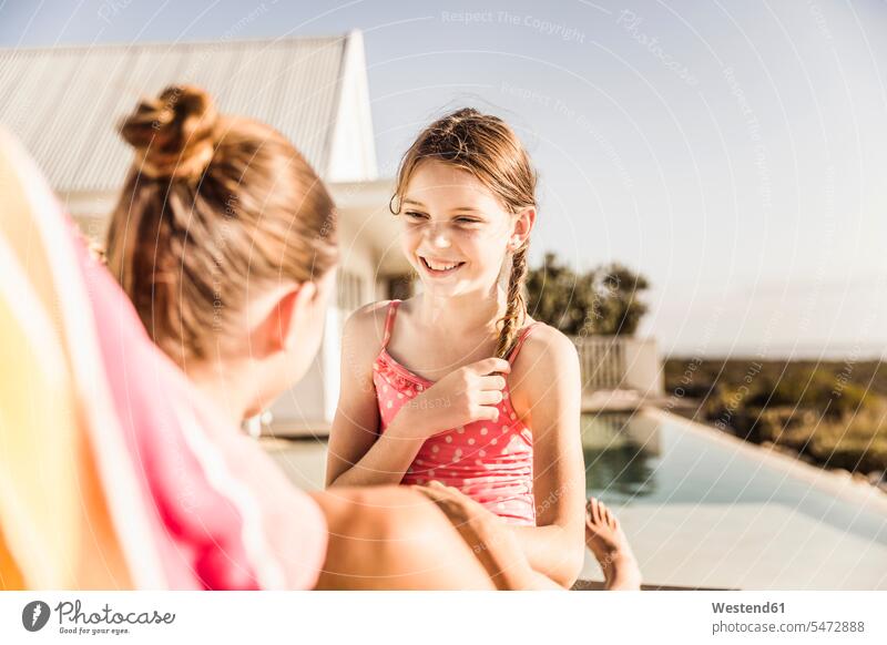 Porträt eines glücklichen Mädchens mit ihrer Mutter am Pool Touristen Badebekleidung Badeanzuege Badeanzüge reden Jahreszeiten sommerlich Sommerzeit entspannen