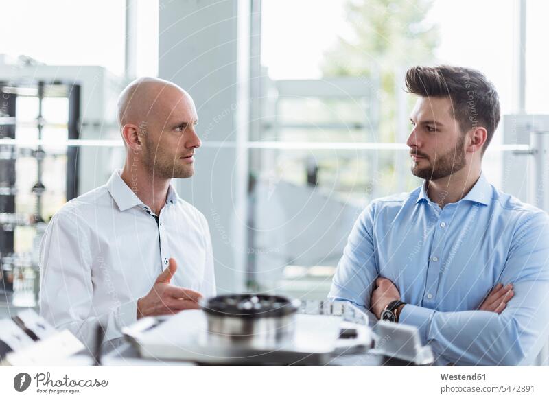 Zwei Männer diskutieren in der Firma über ein Produkt Produkte besprechen Besprechung Unternehmen Business Geschäftsleben Geschäftswelt geschäftlich Zweifel
