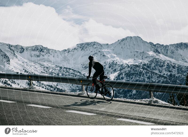 Andorra, Radfahrer auf Bergstraße mit verschneiten Bergen im Hintergrund Fahrradfahrer Gebirgsstraße schneebedeckt Mensch Menschen Leute People Personen