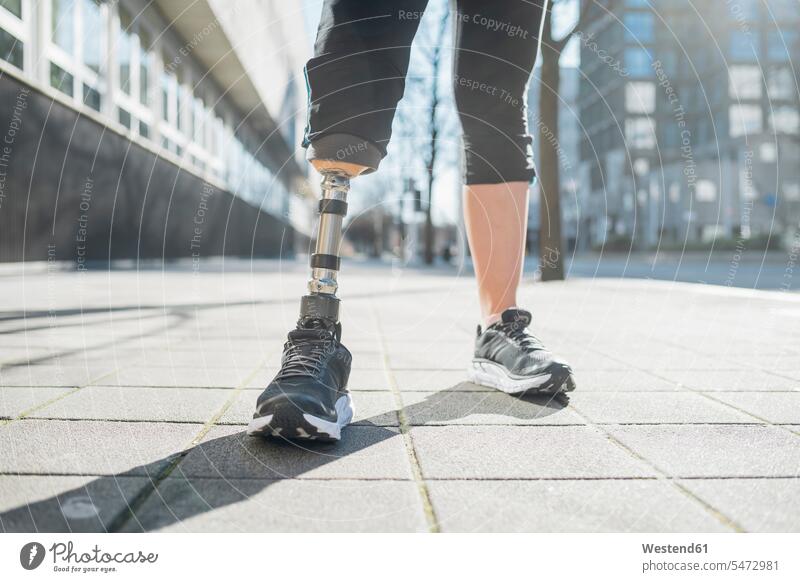Nahaufnahme der Beine einer sportlichen Frau mit Beinprothese in der Stadt stehend steht fit gesund Gesundheit Muße Lifestyles außen draußen im Freien