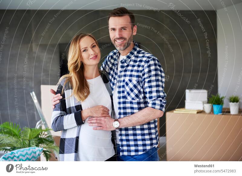 Porträt eines glücklichen Mannes und einer schwangeren Frau beim Einzug in eine neue Wohnung Portrait Porträts Portraits wohnen Wohnungen einziehen Paar Pärchen