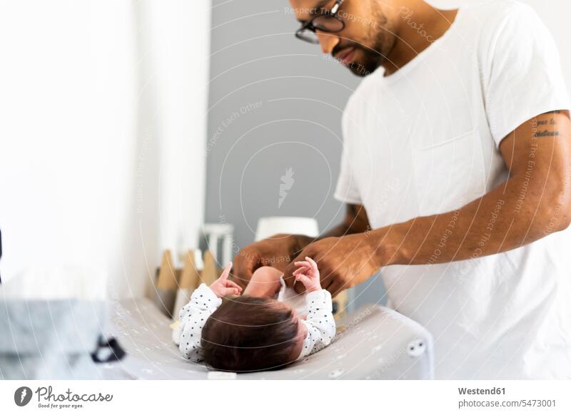 Vater wechselt die Windel seines neugeborenen Babys Afroamerikanisch Afro-Amerikanisch Afroamerikaner Afro-Amerikaner weiß weißes weißer weiss Hygiene