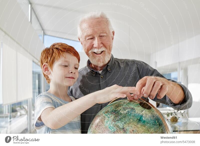 Grossvater und Enkel betrachten den Globus in einer Villa Generation Erdkugel Globen Weltkugel freuen geniessen Genuss Glück glücklich sein glücklichsein