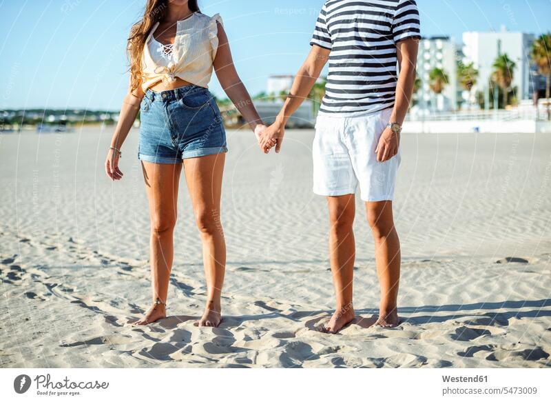 Nahaufnahme eines händchenhaltenden Paares am Strand Beach Straende Strände Beaches Pärchen Partnerschaft Mensch Menschen Leute People Personen