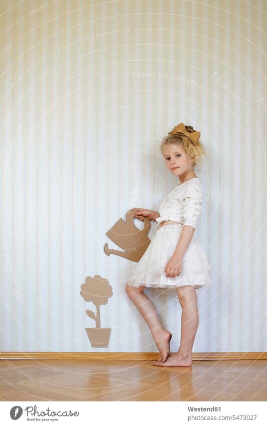 Porträt eines Mädchens, das mit Papp-Giesskanne und Blume spielt Kleider Tapeten Farben Farbtoene Farbton Farbtöne weiss weiße weißer weißes stehend steht Muße