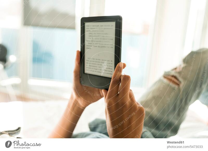 Nahaufnahme einer Frau, die im Bett liegt und ein E-Book liest Betten weiblich Frauen liegen liegend lesen Lektüre eBook Erwachsener erwachsen Mensch Menschen