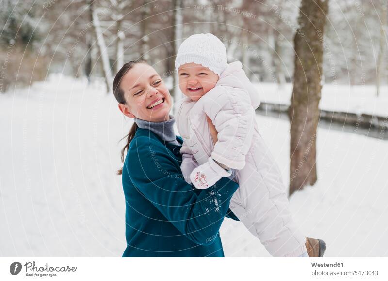Porträt eines glücklichen Mädchens, das sich mit seiner Mutter in einer schneebedeckten Landschaft amüsiert Glück glücklich sein glücklichsein weibliche Babys