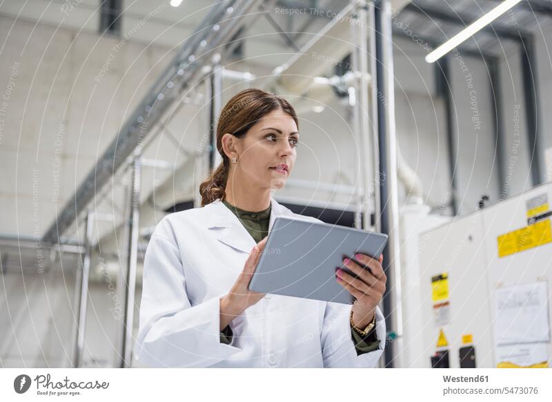 Frau, die Fertigungsmaschinen in einem Hightech-Unternehmen überprüft, mit digitalem Tablet Maschine Automat Tablet Computer Tablet-PC Tablet PC iPad