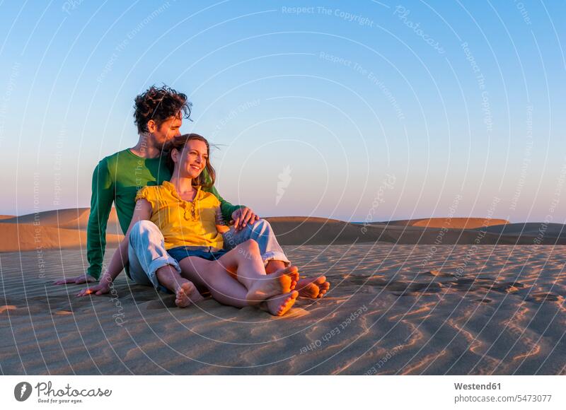 Liebespaar sitzt bei Sonnenuntergang in den Dünen, Gran Canaria, Spanien Leute Menschen People Person Personen Europäisch Kaukasier kaukasisch 2 2 Menschen
