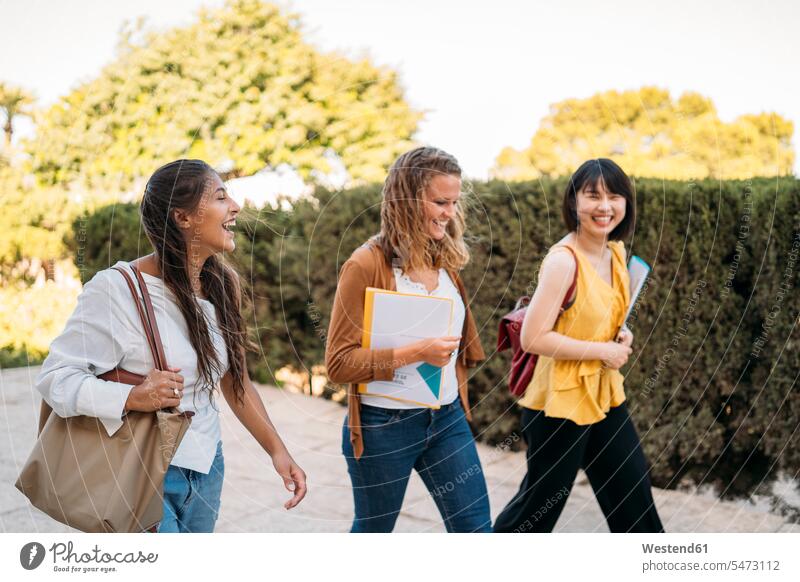 Drei glückliche Freundinnen laufen in einem Park herum Leute Menschen People Person Personen Europäisch Kaukasier kaukasisch Asiaten Asiatisch asiatische