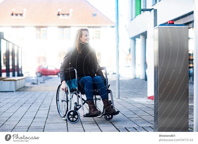Junge Frau im Rollstuhl in der Stadt staedtisch städtisch weiblich Frauen Außenaufnahme draußen im Freien Erwachsener erwachsen Mensch Menschen Leute People