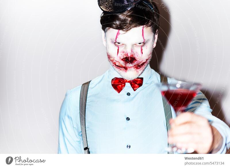 Mann im Halloween-Kostüm stößt mit Cocktail an Abend vor Allerheiligen maskiert feiern zuprosten Party Parties Partys Feste Festtag Festtage Feier Festlichkeit