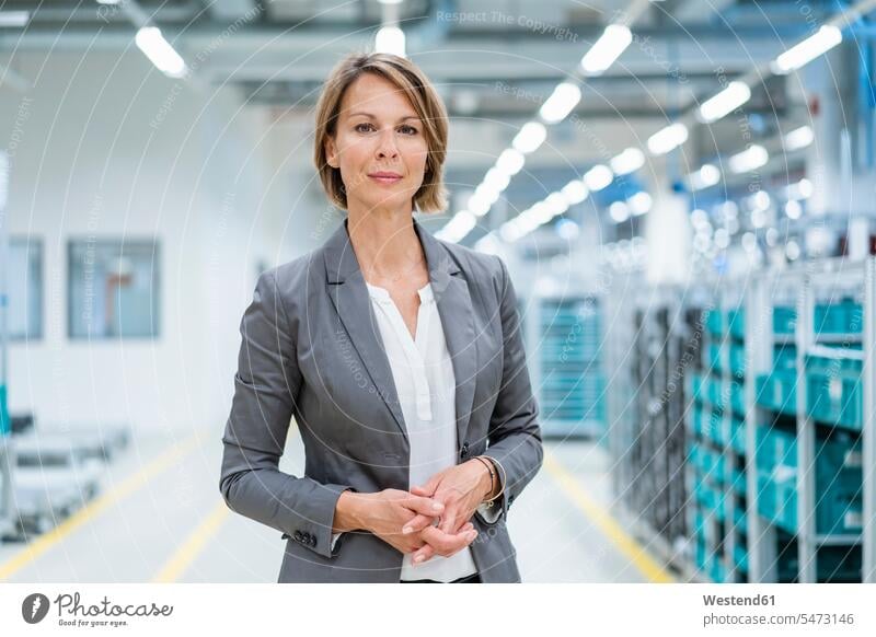 Porträt einer selbstbewussten Geschäftsfrau in einer modernen Fabrik Job Berufe Berufstätigkeit Beschäftigung Jobs geschäftlich Geschäftsleben Geschäftswelt