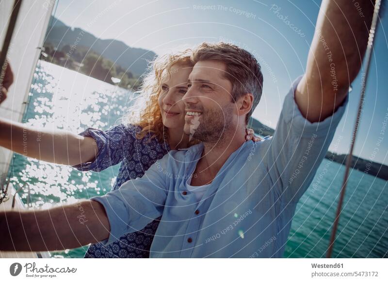 Glückliches Paar auf einem Segelboot Pärchen Paare Partnerschaft Segeln segelnd segelt Segelboote Segelschiff glücklich glücklich sein glücklichsein Mensch