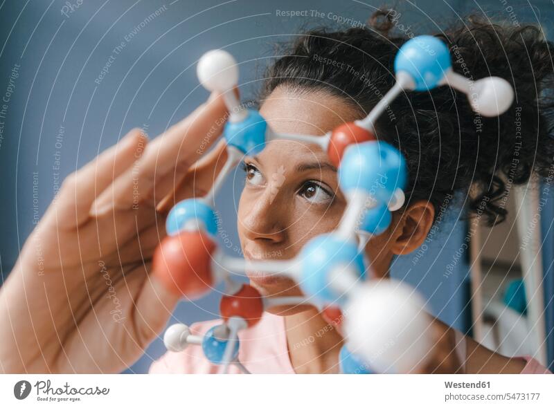 Weibliche Wissenschaftlerin mit Molekülmodell, die nach Lösungen sucht Wissenschaftlerinnen Frau weiblich Frauen Molekularmodell halten wissenschaftlich
