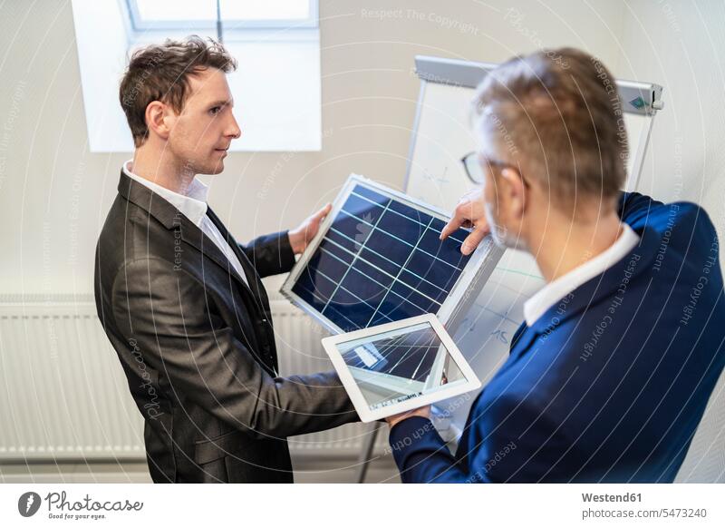 Zwei Geschäftsleute im Büro mit Solarzelle und Tablet diskutieren besprechen Besprechung Tablet Computer Tablet-PC Tablet PC iPad Tablet-Computer Solarzellen