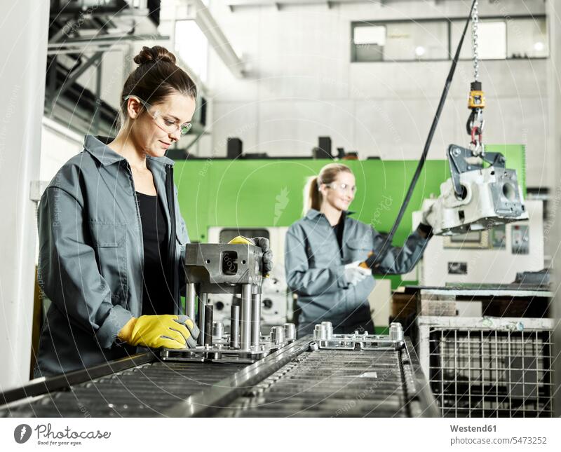 Zwei Frauen arbeiten an einer Maschine Arbeitskleidung Arbeitsbekleidung Männerberuf Zusammenarbeit Kooperation zusammenarbeiten zusammen arbeiten Teamwork