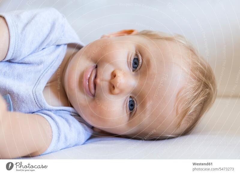 Porträt eines blonden Baby-Mädchens auf der Couch liegend Portrait Porträts Portraits blonde Haare blondes Haar liegt Sofa Couches Liege Sofas Babies Babys
