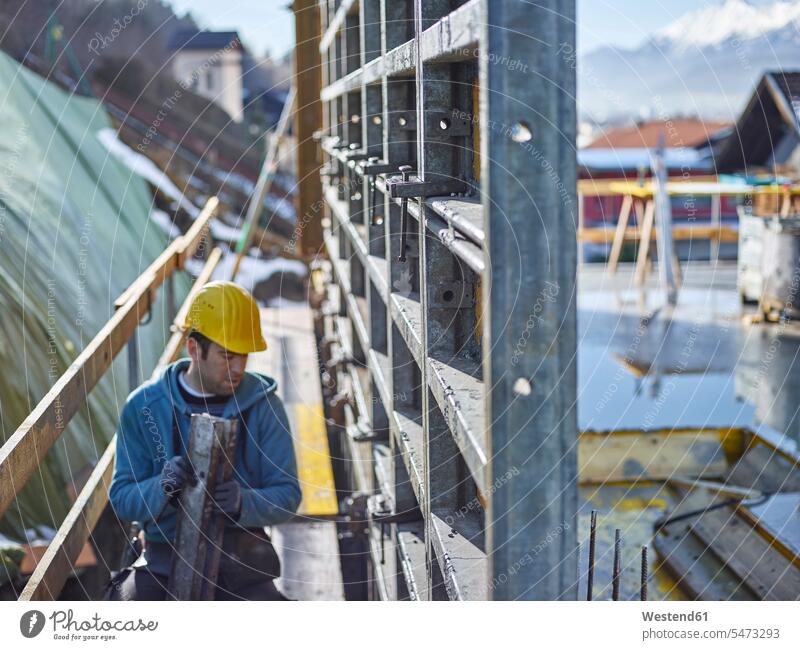Bauarbeiter, der auf Sperrholz arbeitet Beruf Berufstätigkeit Berufe Beschäftigung Jobs Können Fähigkeit Fertigkeit Könnerschaft bearbeiten Schalungsplatte