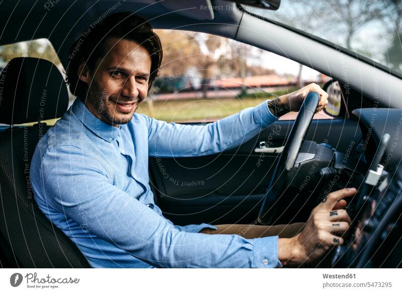 Porträt eines lächelnden Geschäftsmannes, der Auto fährt und ein Mobiltelefon als Navigationssystem benutzt Businessmann Businessmänner Geschäftsmänner fahren