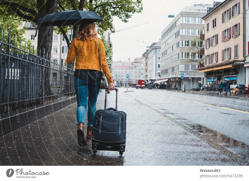 Junge Frau geht an einem regnerischen Tag in der Stadt spazieren, Zürich, Schweiz Leute Menschen People Person Personen Europäisch Kaukasier kaukasisch