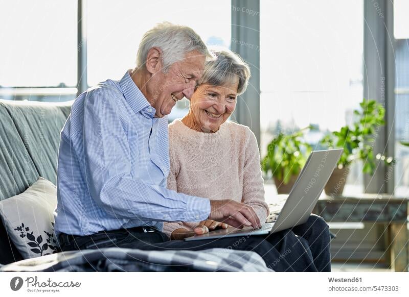 Senior Paar sitzt zusammen auf Couch mit Laptop Sofa Couches Liege Sofas Gemeinsam Zusammen Miteinander Pärchen Paare Partnerschaft Seniorenpaar älteres Paar