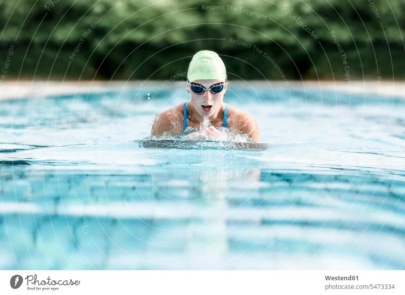 Junge Frau schwimmt im Schwimmbad, Brustschwimmen Sommer Sommerzeit sommerlich Schwimmerin Schwimmerinnen Fitness fit Gesundheit gesund Aktivität Aktivitaet