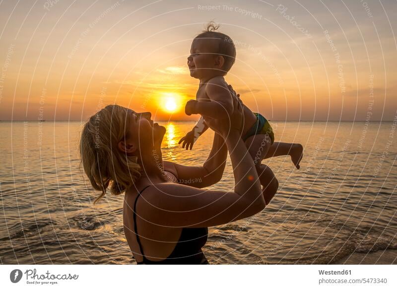Vietnam, Insel Phu Quoc, Strand von Ong Lang, Mutter hält Baby bei Sonnenuntergang am Strand Außenaufnahme außen draußen im Freien Sonnenuntergänge Stimmung