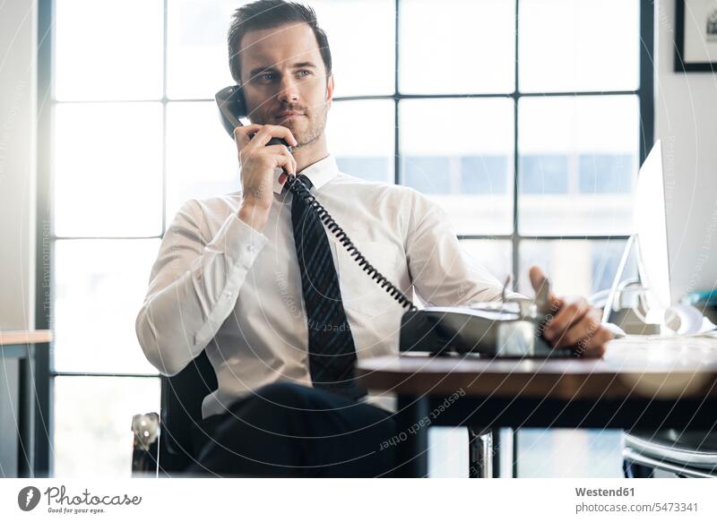 Geschäftsmann im Büro mit Vintage Retro-Telefon telefonieren Office Büros altmodisch Businessmann Businessmänner Geschäftsmänner Kommunikation Telekommunikation