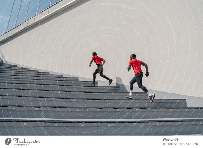 Sportler mit Gesichtsmasken beim Treppensteigen Freunde Kameradschaft rennen Farben Farbtoene Farbton Farbtöne rote roter rotes Leistungen Dynamik dynamisch