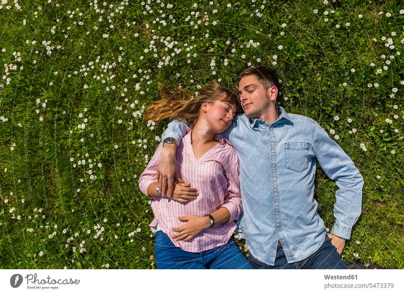 Glückliches junges Paar entspannt auf Gras in einem Park, Blick von oben Sommer Sommerzeit sommerlich Auszeit Alles hinter sich lassen abschalten entspannen