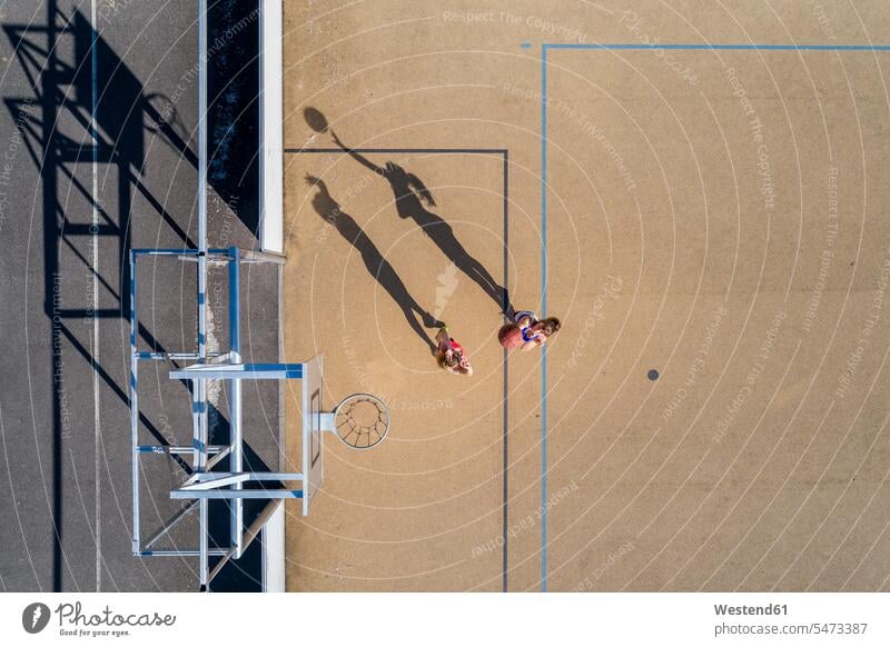 Junge Frauen beim Basketball spielen, Luftaufnahme Basketballkorb Basketballkoerbe Basketballkörbe Sport aktiv Außenaufnahme draußen im Freien Ball Bälle Agil