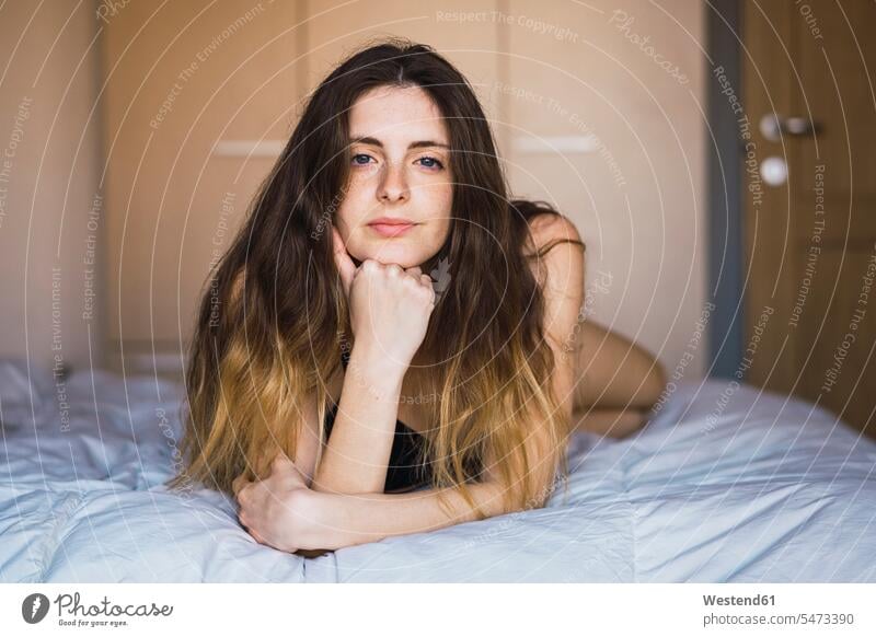 Porträt einer jungen Frau mit auf dem Bett liegendem Haar Portrait Porträts Portraits liegt Betten weiblich Frauen Erwachsener erwachsen Mensch Menschen Leute
