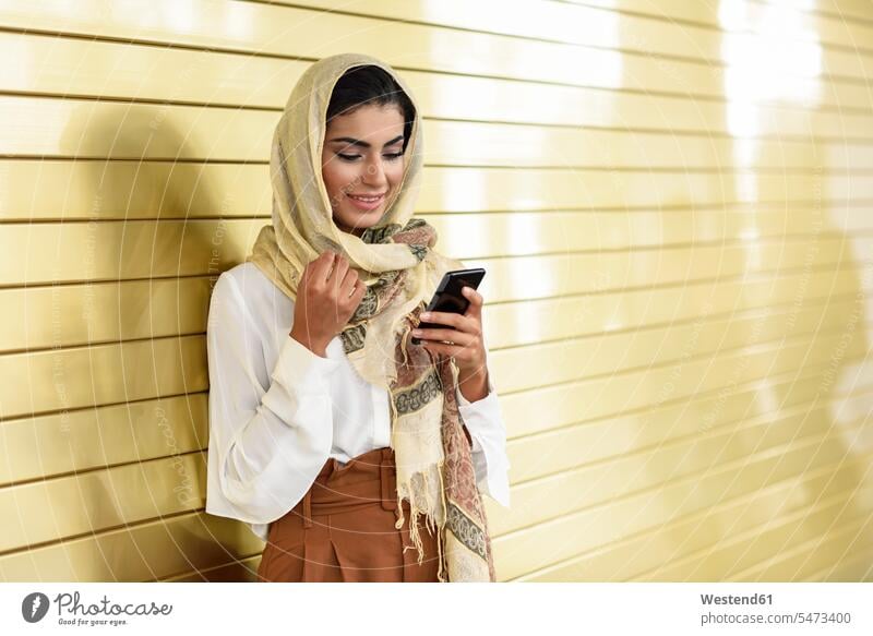 Spanien, Granada, junge arabische Touristin mit Hidschab, die ein Smartphone benutzt Frau weiblich Frauen Islam Araberin Araberinnen arabisches arabischer gehen