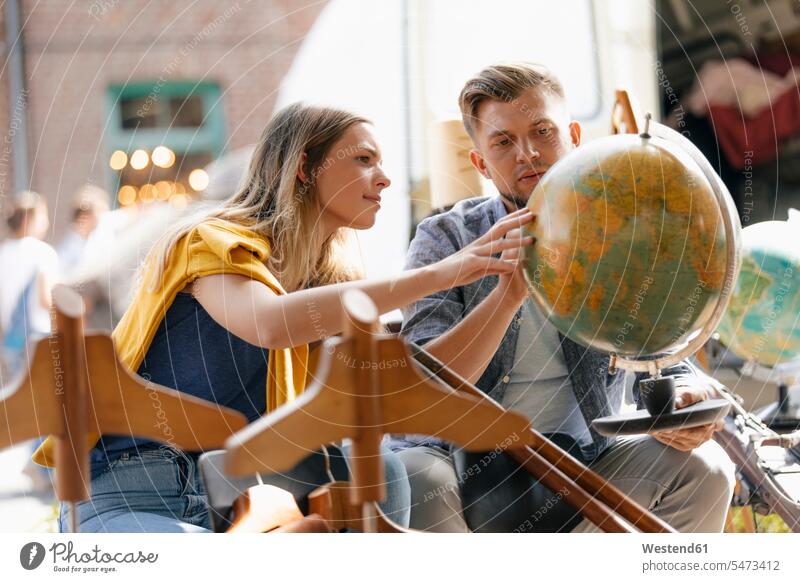 Belgien, Tongeren, junges Paar begutachtet Globus auf einem Antiquitätenflohmarkt Weltkugel Erdkugel Globen mustern musternd untersuchen prüfen begutachten