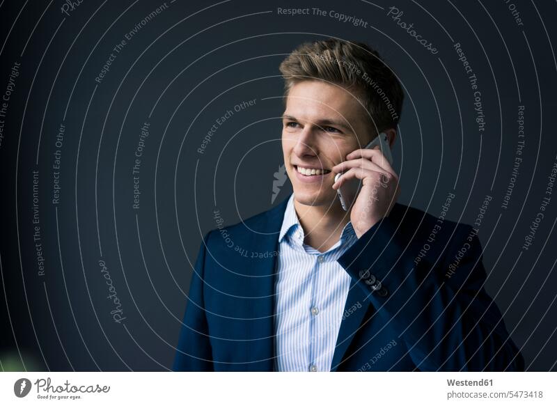 Porträt eines lächelnden jungen Geschäftsmannes am Handy Mobiltelefon Handies Handys Mobiltelefone Portrait Porträts Portraits telefonieren anrufen Anruf
