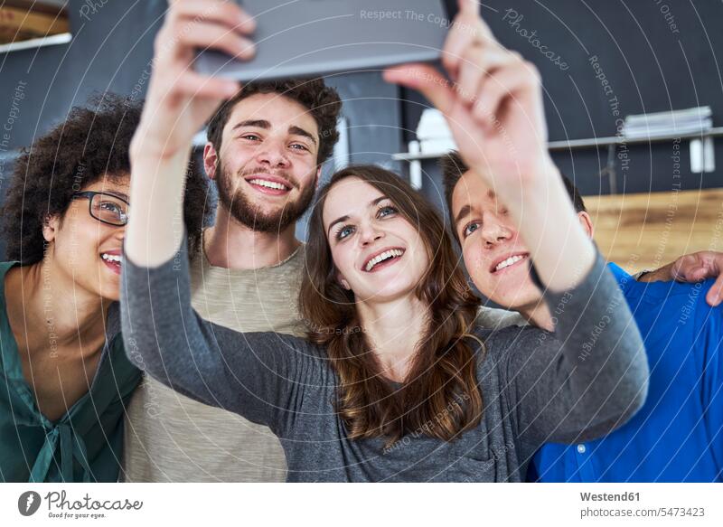 Lächelnde Mitarbeiter machen ein Selfie im Büro Selfies Coworker Kollegen Arbeitskollegen Gemeinsam Zusammen Miteinander Office Büros Arbeitsplatz Arbeitsstätte