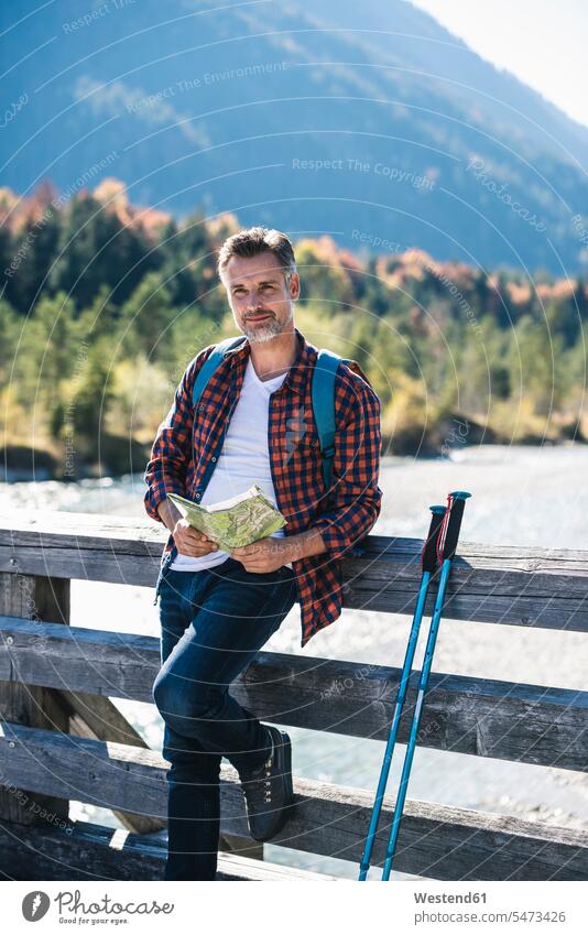 Österreich, Alpen, Mann beim Wandern mit Landkarte auf einer Brücke Europäer Europäisch Kaukasier kaukasisch reifer Mann reife Männer 45-50 Jahre