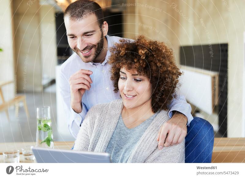Glücklicher Mann und Frau teilen Tablette in modernen Büro Kollegen Arbeitskollegen Tablet Computer Tablet-PC Tablet PC iPad Tablet-Computer Office Büros