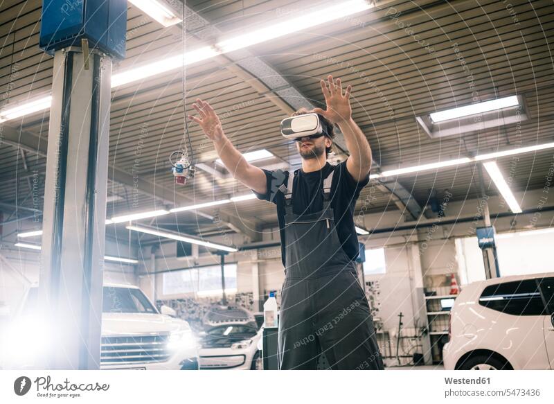 Automechaniker mit VR-Brille in einer Werkstatt Job Berufe Berufstätigkeit Beschäftigung Jobs Gewerbe industriell Industrien Monteur KFZ Verkehrsmittel
