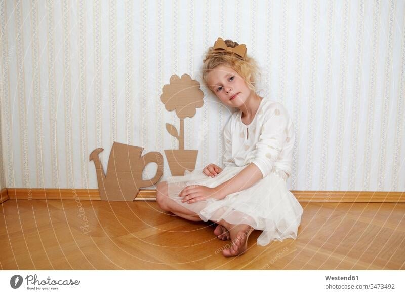 Porträt eines Mädchens, das mit Papp-Giesskanne und Blume spielt Kleider Tapeten sitzend sitzt Farben Farbtoene Farbton Farbtöne weiss weiße weißer weißes Muße