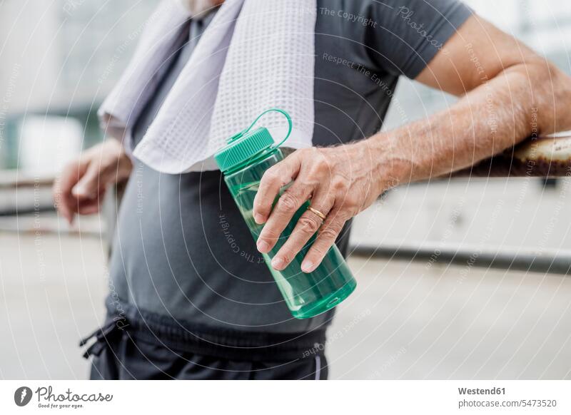 Nahaufnahme eines älteren Mannes, der eine Wasserflasche hält, während er in der Stadt steht Farbaufnahme Farbe Farbfoto Farbphoto Außenaufnahme außen draußen