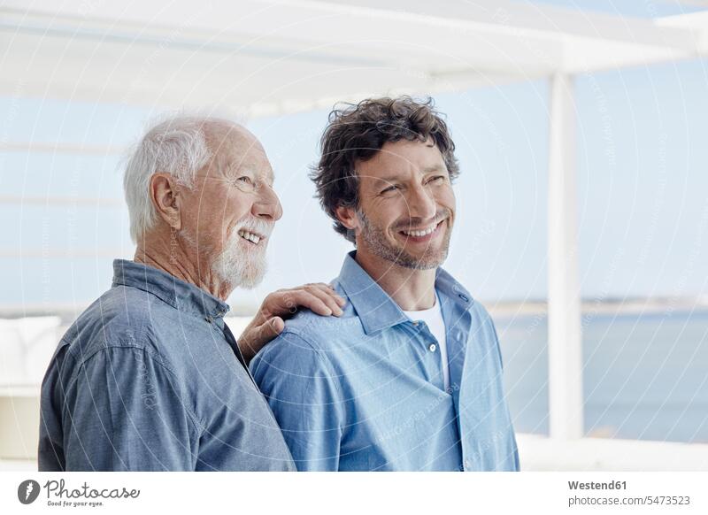 Porträt eines selbstbewussten älteren Mannes mit erwachsenem Sohn in einem Strandhaus Leute Menschen People Person Personen Europäisch Kaukasier kaukasisch 2