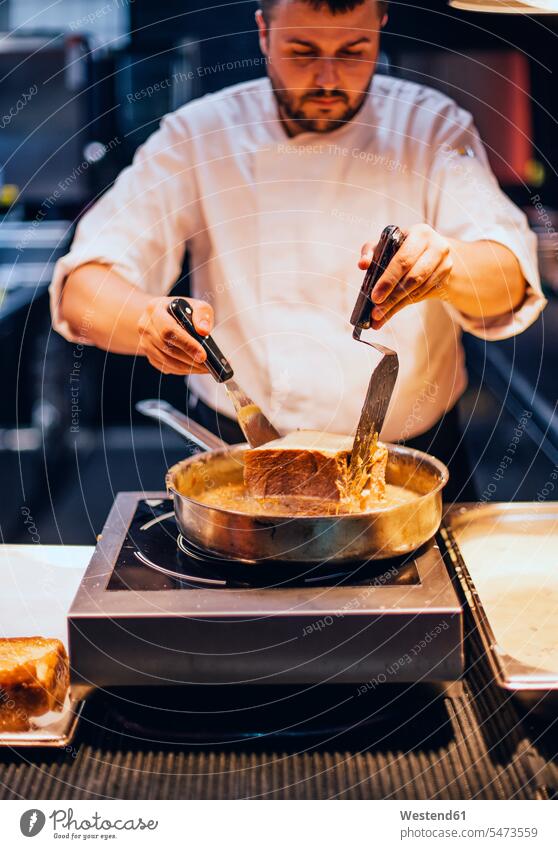 Koch, der in der Küche eines Restaurants einen Kuchen backt Job Berufe Berufstätigkeit Beschäftigung Jobs Gastronomie Koeche Kuechenchef Kuechenchefs Köche
