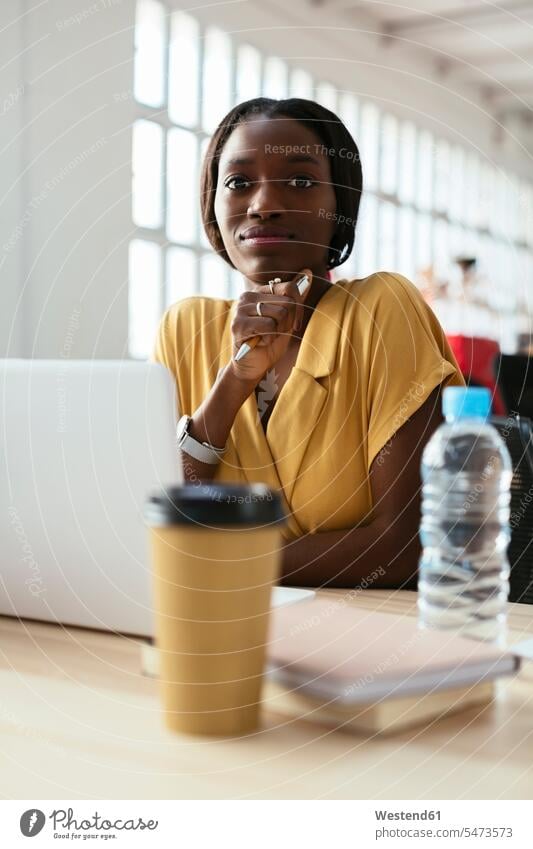 Porträt einer selbstbewussten jungen Frau am Schreibtisch im Büro Office Büros Arbeitstisch Schreibtische weiblich Frauen Zuversicht Zuversichtlich