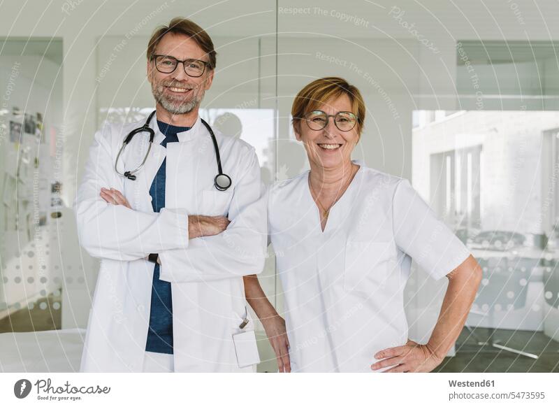 Porträt eines selbstbewussten Arztes und Assistenten in der medizinischen Praxis Job Berufe Berufstätigkeit Beschäftigung Jobs Gesundheit Gesundheitswesen