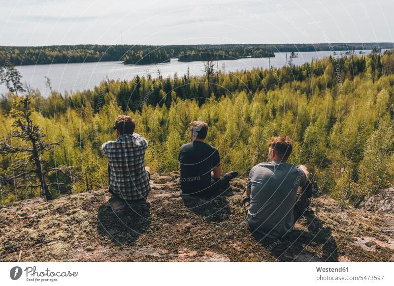 Freunde sitzen auf einem Hügel und schauen auf einen See, Nykoping, Schweden sitzend sitzt Friede friedlich auf Achse in Bewegung Abenteuer abenteuerlich Travel